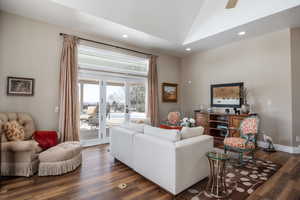 Living room featuring lofted ceiling, recessed lighting, baseboards, french doors, and dark wood-style floors