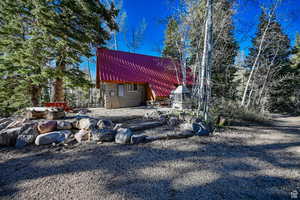 Back of property featuring an outbuilding and metal roof