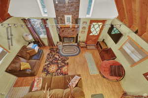 Living area with a large fireplace, visible vents, and wood finished floors