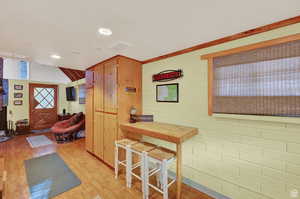 Kitchen featuring light wood-type flooring, brick wall, and recessed lighting