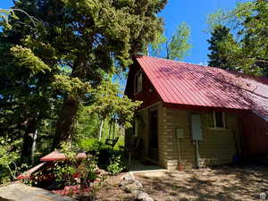 View of home's exterior featuring stone siding, a patio area, and metal roof