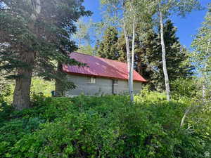 View of side of home featuring metal roof and brick siding