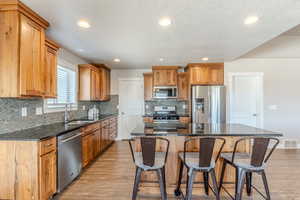 Kitchen with appliances with stainless steel finishes, a sink, visible vents, and light wood-style floors