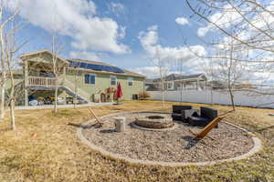 View of yard featuring fence, a fire pit, and a patio