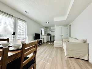 Living area featuring light wood-style floors, french doors, visible vents, and a textured ceiling