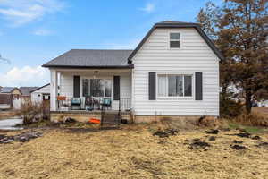 View of front of house with a porch and roof with shingles