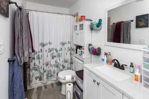 Full bathroom featuring toilet, shower / bath combo, wood finished floors, and vanity