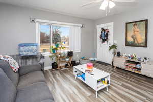 Living room featuring ceiling fan, baseboards, and wood finished floors