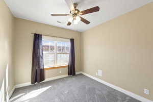 Unfurnished room featuring carpet floors, a ceiling fan, visible vents, and baseboards