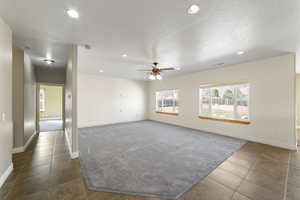 Carpeted spare room with ceiling fan, baseboards, and recessed lighting