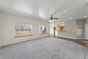 Unfurnished living room with carpet, baseboards, and recessed lighting