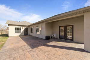 Back of house with roof with shingles, a patio area, fence, and stucco siding