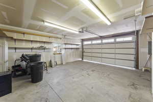 Garage featuring electric panel and a garage door opener