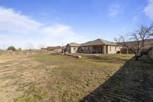 View of yard with a fenced backyard and a patio