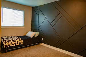 Bedroom featuring wall paneling carpet flooring