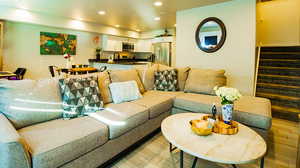 Living room with stairway, recessed lighting, and light wood-style flooring