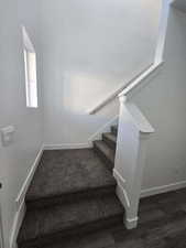 Staircase featuring baseboards and wood finished floors