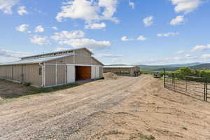 View of barn featuring a mountain view and round pen