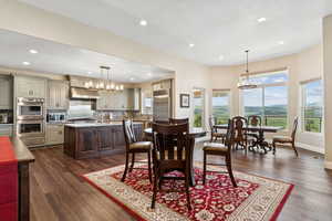 Dining room with a chandelier, recessed lighting, dark wood-style flooring, baseboards, and a textured ceiling