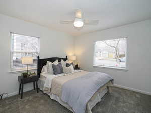 Carpeted bedroom with ceiling fan and baseboards