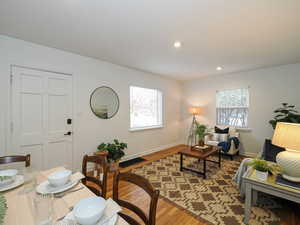 Living room featuring light wood-style flooring, baseboards, a wealth of natural light, and recessed lighting