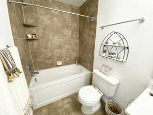 Full bathroom with shower / bathtub combination with curtain, toilet, and tile patterned floors