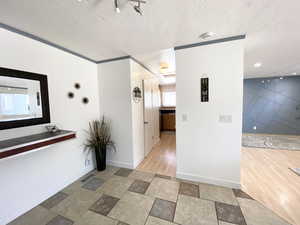 Corridor with a textured ceiling, stone tile floors, and baseboards