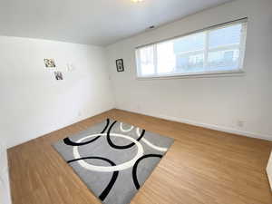 Unfurnished room featuring visible vents, baseboards, and wood finished floors