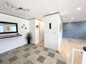 Hallway featuring recessed lighting, rail lighting, a textured ceiling, and baseboards