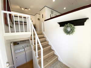 Staircase with baseboards, visible vents, wood finished floors, separate washer and dryer, and recessed lighting