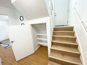 Stairs featuring a textured ceiling and wood finished floors