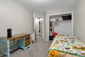 Bedroom with baseboards, a closet, and light colored carpet