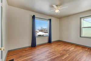 Unfurnished room featuring ceiling fan, light wood-type flooring, visible vents, and baseboards