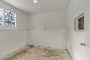Empty room featuring unfinished concrete floors