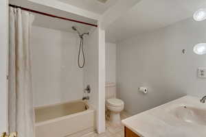 Bathroom featuring toilet, shower / bath combo, vanity, and tile patterned floors