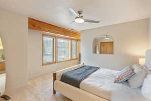 Carpeted bedroom featuring a textured ceiling and ceiling fan