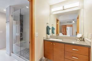 Full bathroom featuring vanity, recessed lighting, a ceiling fan, and a stall shower