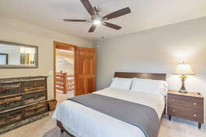 Bedroom featuring a ceiling fan, visible vents, and light carpet