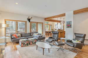 Living area featuring light wood-style flooring, recessed lighting, beamed ceiling, and baseboards