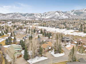 Snowy aerial view featuring a residential view and a mountain view