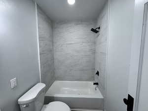 Bathroom featuring shower / bath combination and toilet