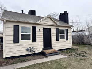 Bungalow with entry steps, roof with shingles, a chimney, and central air condition unit