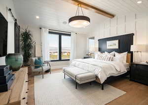 Bedroom with lofted ceiling with beams, a barn door, light wood-style flooring, and recessed lighting