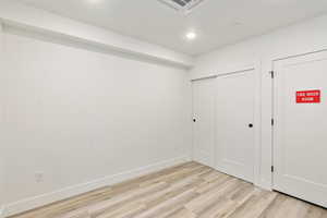 Unfurnished bedroom featuring recessed lighting, visible vents, baseboards, a closet, and light wood-type flooring