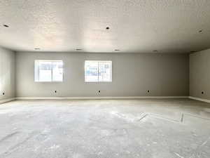 Empty room featuring a textured ceiling and baseboards