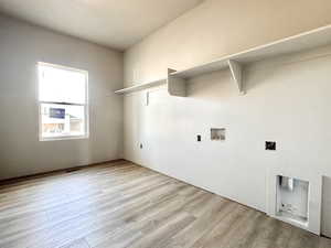 Laundry area featuring laundry area, visible vents, washer hookup, and wood finished floors