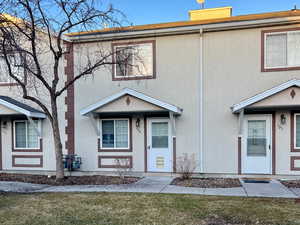 View of property featuring a front lawn and stucco siding