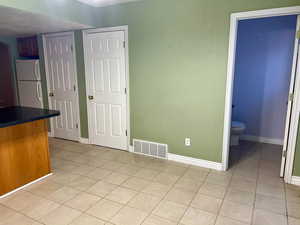 Interior space featuring visible vents, baseboards, and light tile patterned floors