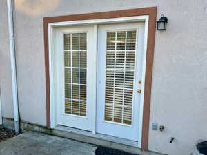 Entrance to property featuring a patio area, central AC unit, and stucco siding