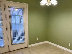 Interior space with a chandelier, visible vents, a textured ceiling, and baseboards